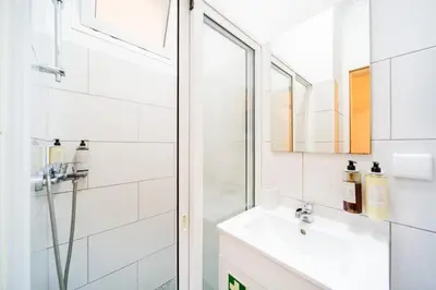a white bathroom with a sink and a shower at Casa na Ilha IV in Funchal