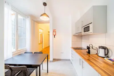 a kitchen with white cabinets and a table with chairs at Casa na Ilha IV in Funchal