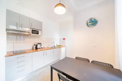 a kitchen with white cabinets and a table with chairs at Casa na Ilha IV in Funchal