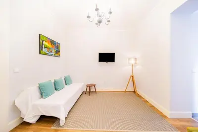 a living room with a white couch and a tv at Casa na Ilha IV in Funchal