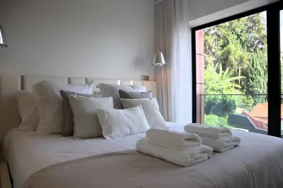 a white bed with white pillows and a window at Seaside XXI-10, By OP in Funchal