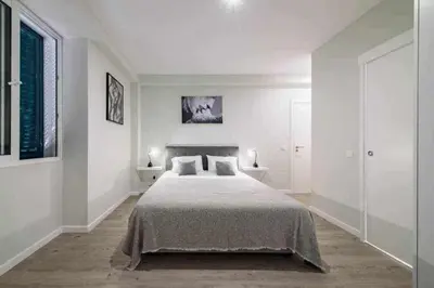 a white bedroom with a bed and two lamps at Pena Apartments - B by MTH in Funchal