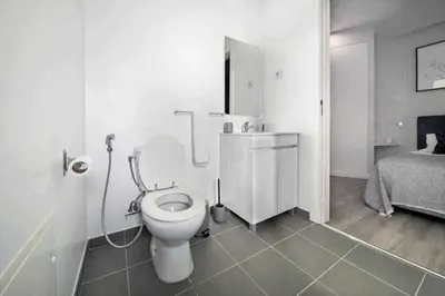 a white bathroom with a toilet and a bed at Pena Apartments - B by MTH in Funchal