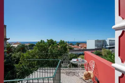 a patio with a table and chairs on a balcony at Casa Strelitzia by An Island Apart in Funchal