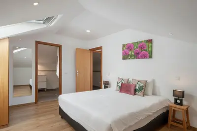 a bedroom with a white bed and a mirror at Casa Strelitzia by An Island Apart in Funchal