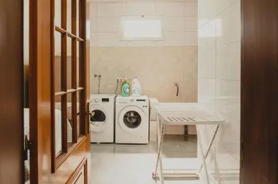a laundry room with a washing machine and a washer at Casa Estrelicia in Ponta do Sol