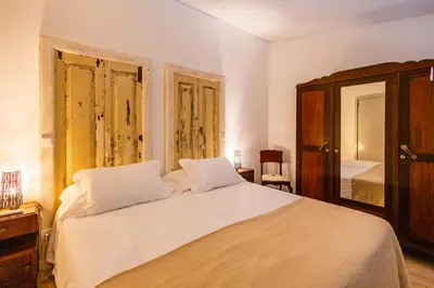 a bedroom with a large white bed with two lamps at Casa Da Avo Clementina in Funchal