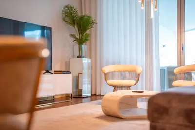 a living room with two chairs and a tv at Suite BK - 3 Pools - Gym - AC - Huge Balcony in Funchal