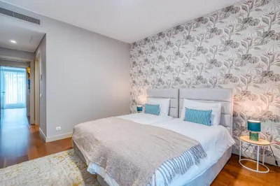 a bedroom with a large white bed with blue pillows at Suite BK - 3 Pools - Gym - AC - Huge Balcony in Funchal