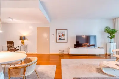 a living room with a table and a tv at Suite BK - 3 Pools - Gym - AC - Huge Balcony in Funchal