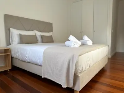 a bedroom with a large bed with two towels on it at Tropical Garden in Caniço