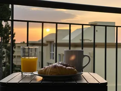 a plate of food and a glass of orange juice and a pastry at Tropical Garden in Caniço