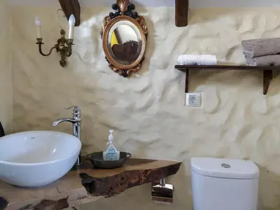 a bathroom with a sink and a toilet and a mirror at Achadinha - Mountain Cottage in Arco da Calheta