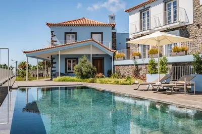 a villa with a swimming pool and a house at Casas da Luz by Homie in Ponta do Sol