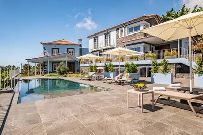 a villa with a swimming pool and patio furniture at Casas da Luz by Homie in Ponta do Sol