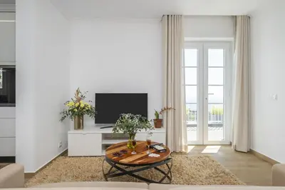a living room with a table and a tv at Casas da Luz by Homie in Ponta do Sol