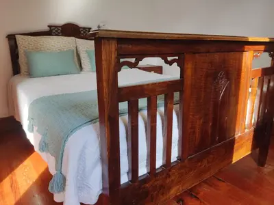 a wooden bed in a room with a wooden floor at Peaceful place in São Vicente in São Vicente