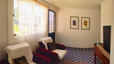 a living room with a couch and chairs and a tv at Peaceful place in São Vicente in São Vicente
