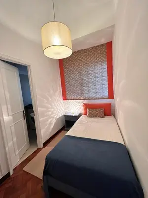 a bedroom with a bed and a red wall at Fatima`s House in Funchal