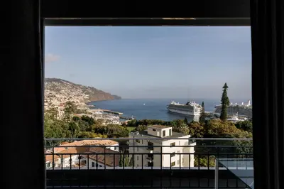 a window with a view of the ocean and a cruise ship at Fatima`s House in Funchal