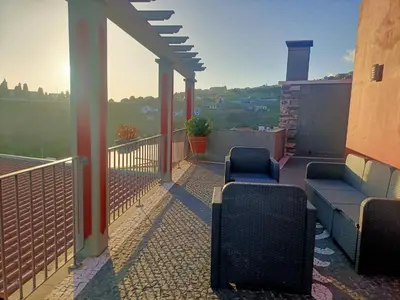 a balcony with chairs and a view of the city at Casa RuMa ao Sol in Ponta do Sol
