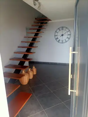 a staircase in a room with a clock on the wall at Casa RuMa ao Sol in Ponta do Sol