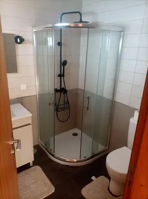 a bathroom with a glass shower with a toilet at Casa RuMa ao Sol in Ponta do Sol