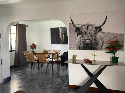 a dining room with a picture of a cow on the wall at Hollywood villa in Campanário
