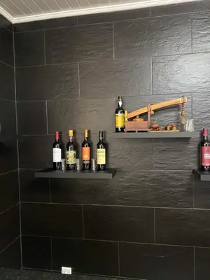 a bunch of bottles of wine on shelves on a wall at Hollywood villa in Campanário
