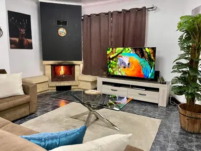 a living room with a television and a fireplace at Hollywood villa in Campanário