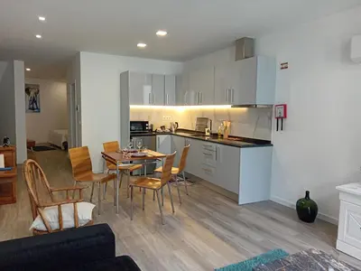 a kitchen and dining room with a table and chairs at Living Caboqueira in Funchal