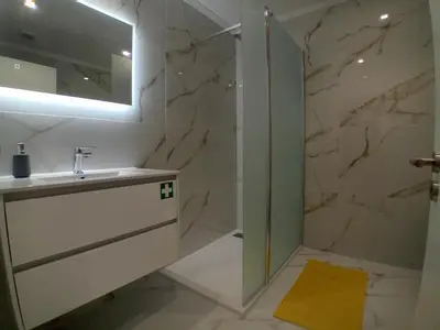 a bathroom with a sink and a shower at Living Caboqueira in Funchal
