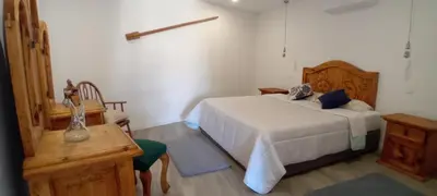 a bedroom with a bed and a dresser and a table at Living Caboqueira in Funchal