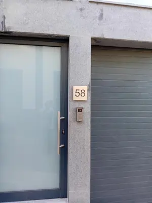 a garage door with a sign that next to it at Living Caboqueira in Funchal