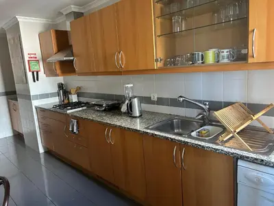 a kitchen with wooden cabinets and a sink at In Town View in Funchal