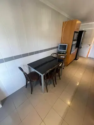 a room with a table and chairs and a kitchen at In Town View in Funchal