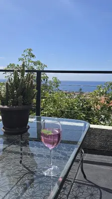a glass of wine sitting on a table on a balcony at Vila Loki in Funchal