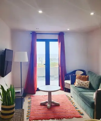 a living room with a couch and a table and a window at Vila Loki in Funchal