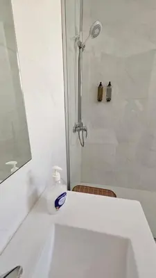 a white bathroom with a shower and a sink at Garden and Seaview Apartment - Free Parking in Funchal