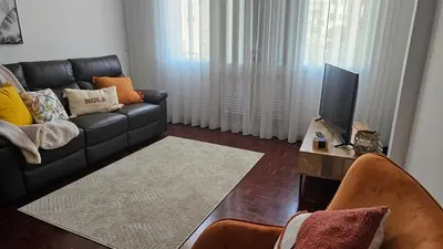 a living room with a black couch and a television at Garden and Seaview Apartment - Free Parking in Funchal