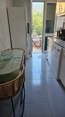 a kitchen with a table and a view of a balcony at Garden and Seaview Apartment - Free Parking in Funchal