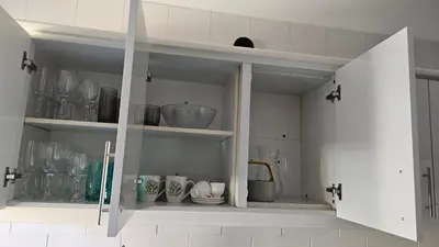 a white cabinet with dishes and vases in it at Garden and Seaview Apartment - Free Parking in Funchal