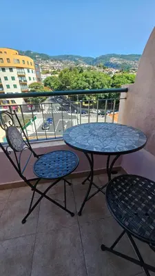 a table and chairs on a balcony with a view of a street at Garden and Seaview Apartment - Free Parking in Funchal