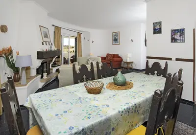 a dining room with a table and a living room at LGS32V5 moradia grande conforto, lugar sossegado in Lagos