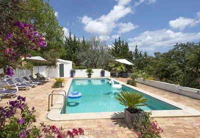 a swimming pool in a yard with chairs and flowers at LGS32V3 moradia de grande conforto in Lagos
