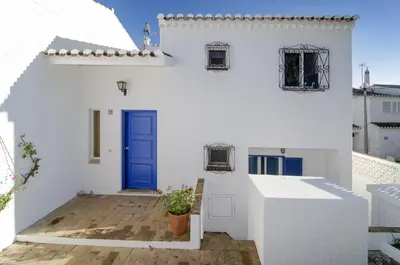 a white house with a blue door at LGS62 V3 casa e jardim a 100mts praia da Luz in Luz
