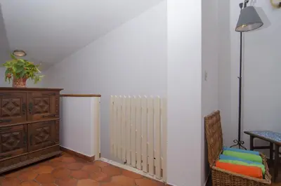 a room with a radiator and a table and a chair at LGS62 V3 casa e jardim a 100mts praia da Luz in Luz