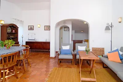 a living room with a couch and a table and chairs at LGS62 V3 casa e jardim a 100mts praia da Luz in Luz