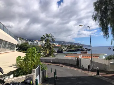 a street light on a sidewalk next to the water at Beach Studio Apartment in Funchal
