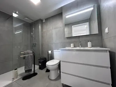 a bathroom with a toilet and a sink and a mirror at Beach Studio Apartment in Funchal